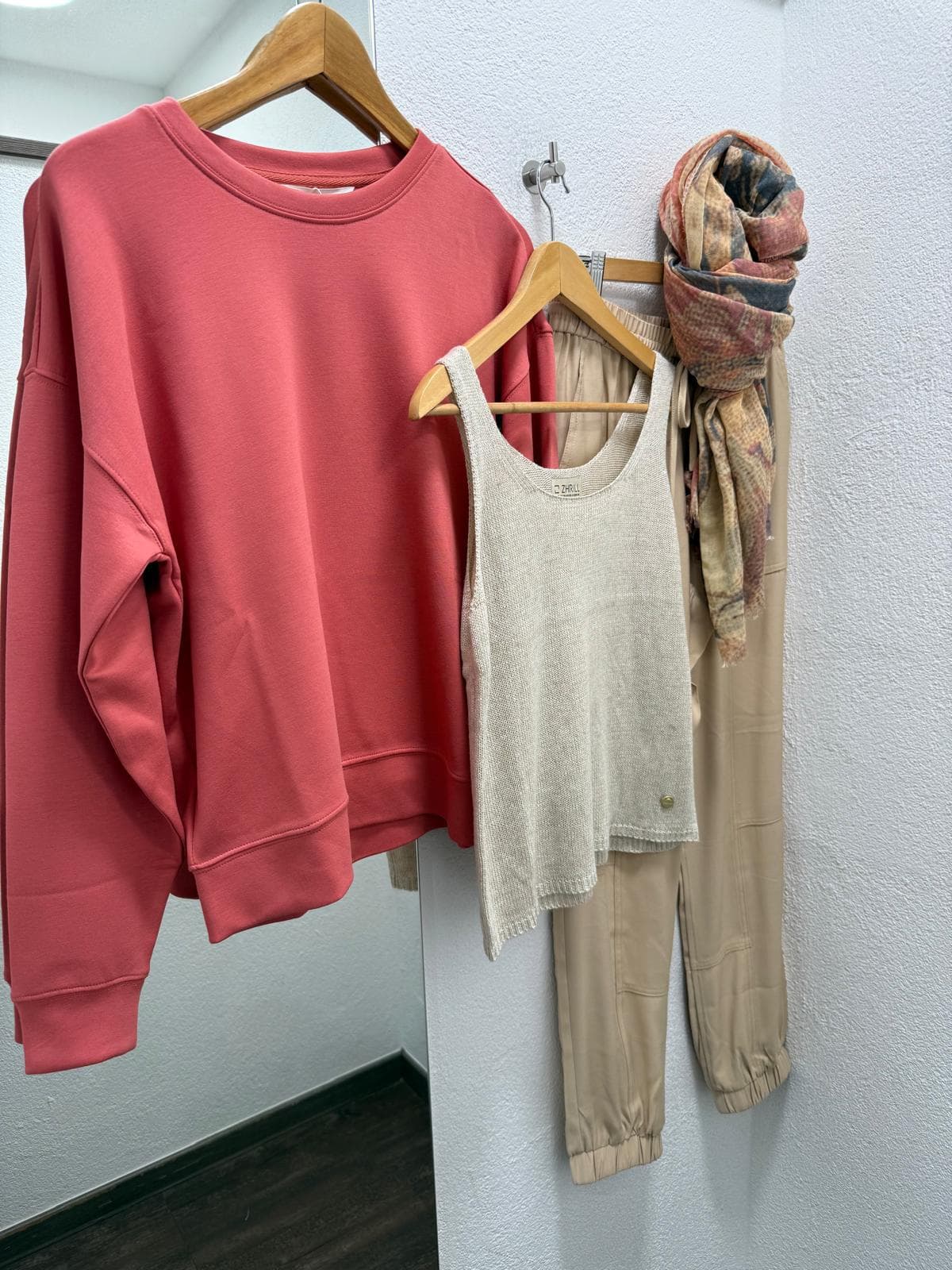 Korallfarbener Pullover und helle Hose bei DRESS by Manu
